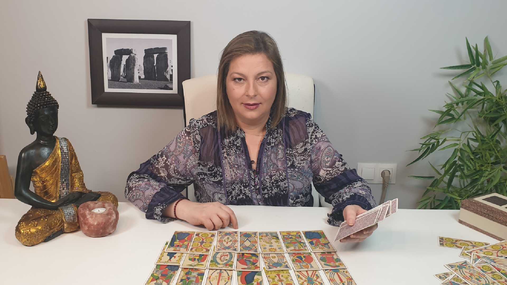 Rosa María solsona Esteban sentada en su mesa con las cartas del tarot.